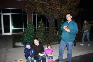 Family Sitting on Curb While Eating